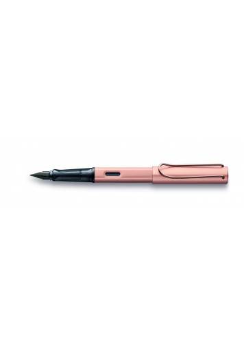 Experience the elegance of the Lx Fountain Pen in rosegold, a sophisticated blend of style and function. Crafted with anodised aluminium and adorned with gold-plated details, this glossy black nib offers a superior writing experience. Ergonomically designed with a transparent grip and equipped with LAMY T 10 blue ink cartridge, it's more than a pen - it's a statement of refinement.